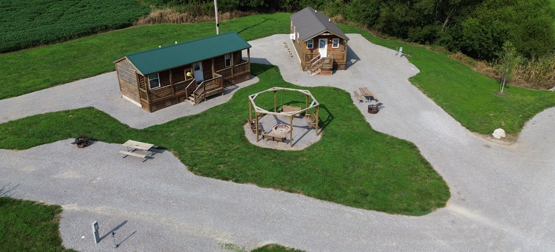 Pod 1 2 Rv Sites and 2 Cabins with a shared yard and a large swing set fire pit.