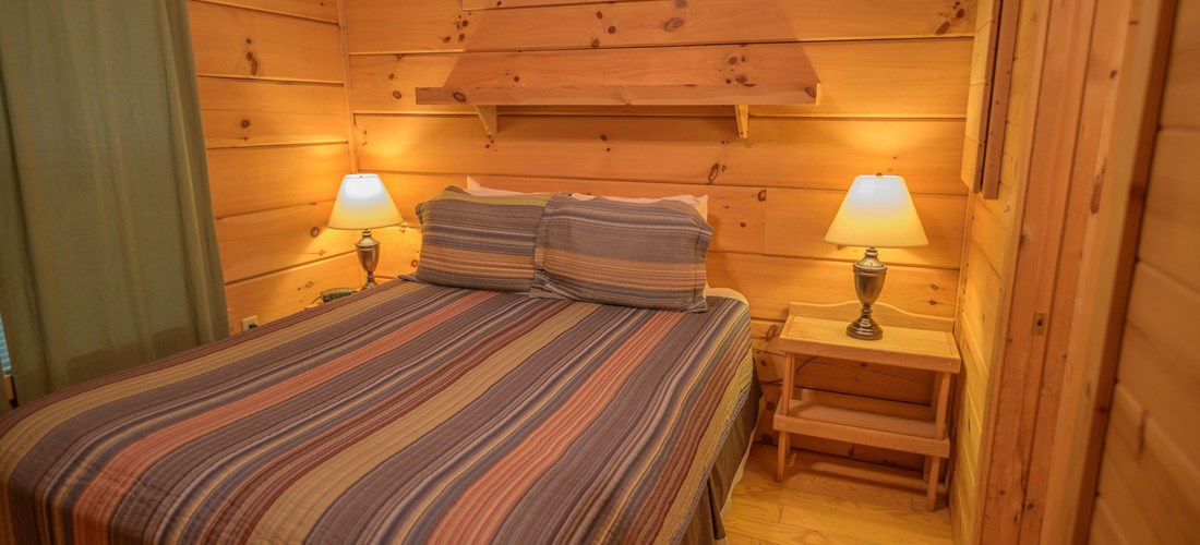 Queen Bed with linens of Deluxe Cabin