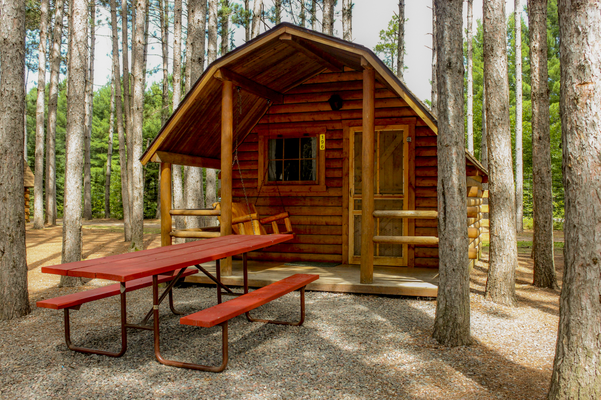 Enjoy our beautiful rustic cabins nestled in the pines.  They are either one bedroom sleeping 4 or two bedrooms sleeping 6.  All have porches, fire rings and picnic table.  Why stay in a motel?