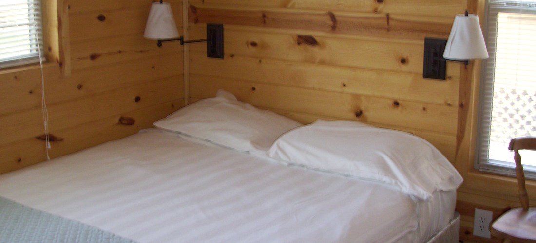 Deluxe Cabin creek-side bedroom with queen sized bed.
