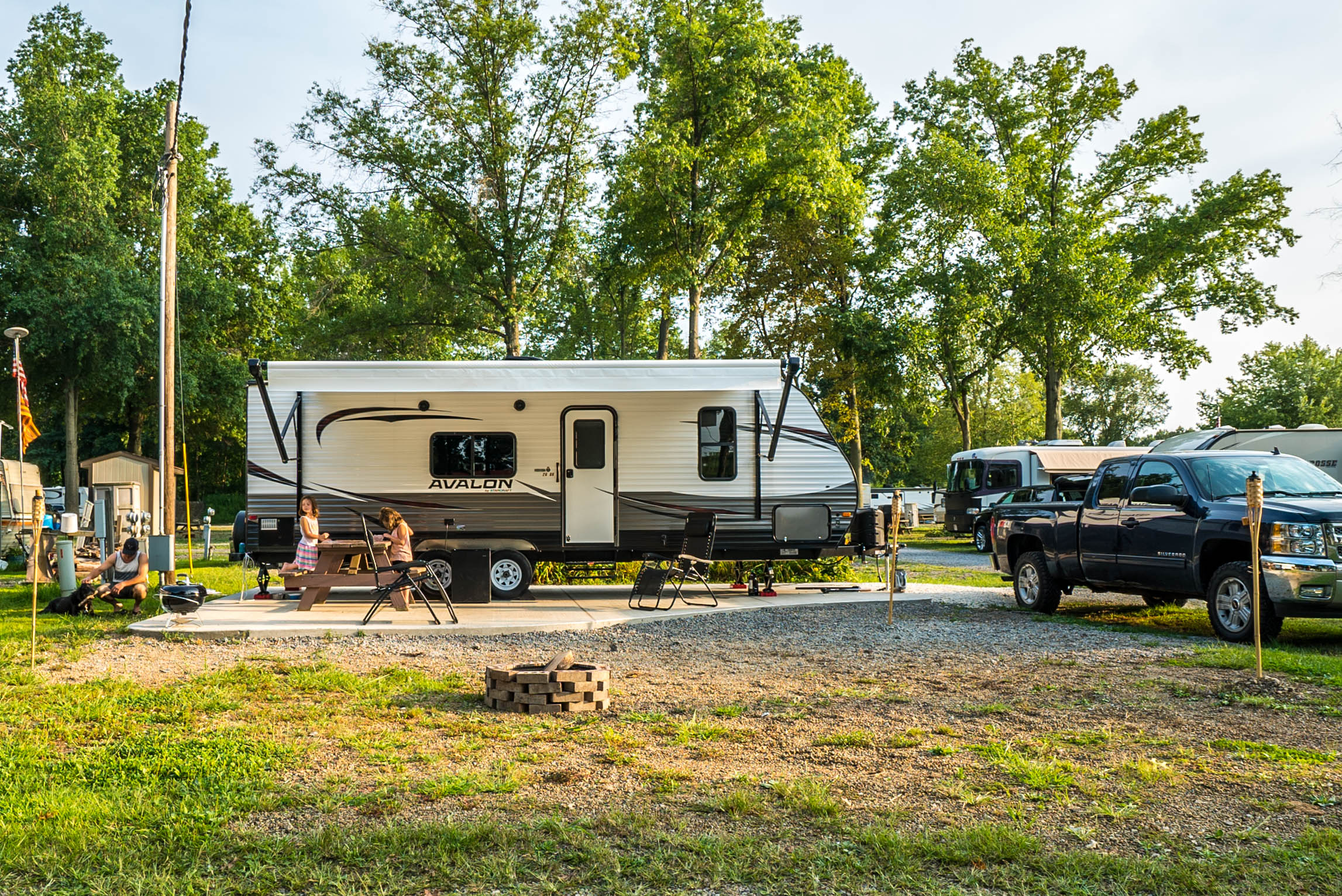 This is an overnight Back-in site at site 220. It is very spacious, has a concrete pad, picnic table, and another outdoor table with 6 chairs.
