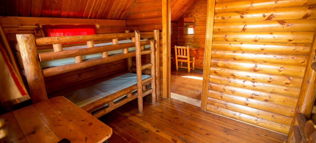 Our 2 bedroom rustic cabins have 2 sets of bunk beds in the front room and a private master bedroom in the back bedroom.
