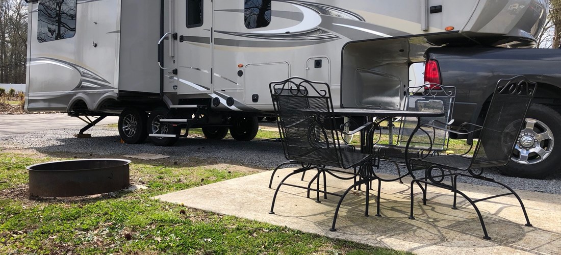 Each site has a small patio with wrought iron furniture and a fire ring.