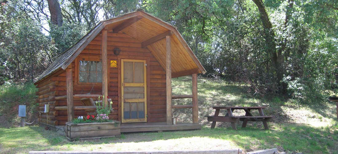 Our small rustic cabins have water on site, electricity inside the cabin, as well as a ceiling fan and heater. Cabins feature a double sized bed and a bunk bed. You bring your bedding. All cabins have wifi access along with a picnic table and bbq grill. Pictured is cabin 112.