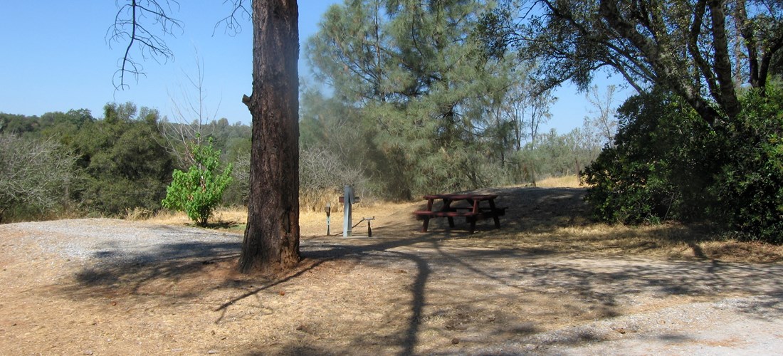 Our water and electric 30 amp back in sites have are located furthest from the freeway along our back fence line and have a view of the valley. It features a picnic table, bbq grill, wifi access, and HD cable tv. Pictured is site 55.
