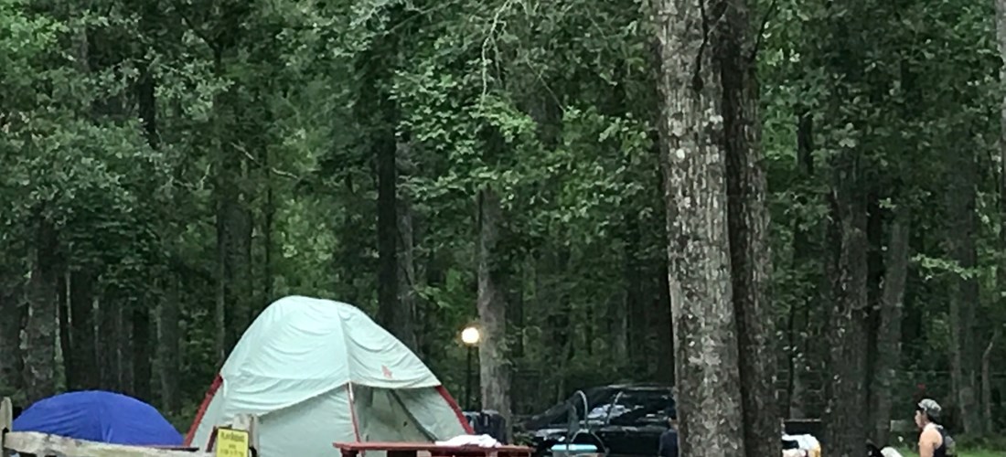 Primitive Tent site with Tent benches close to restroom, building and pavilion. Grills are available for any site.