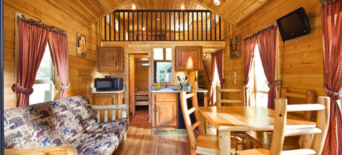k3 lodges feature a private bedroom, loft area, pull out couch, small kitchenette, TV with Direct TV, picnic table, gas BBQ and fire pit for spending time with friends.