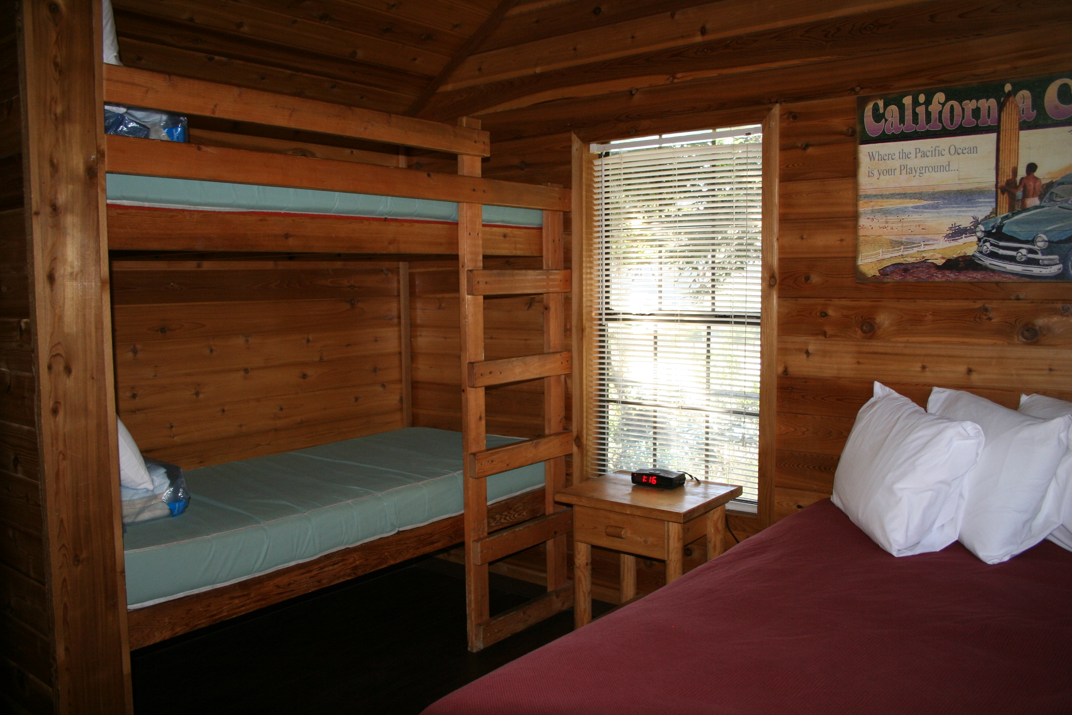 The bedroom has a full size bed and a set of bunks.