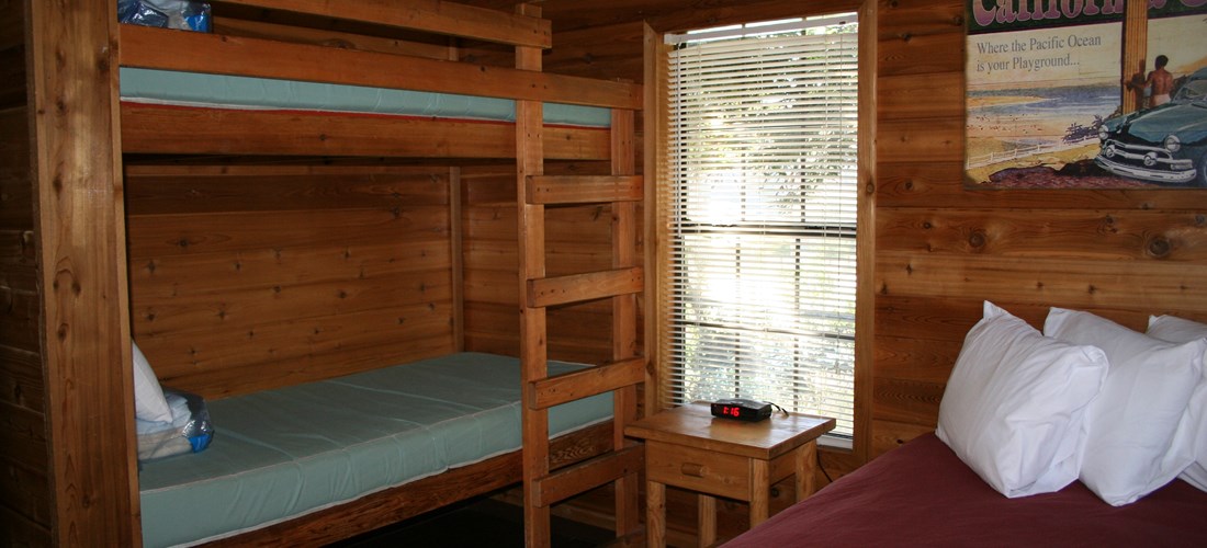 The bedroom has a full size bed and a set of bunks.