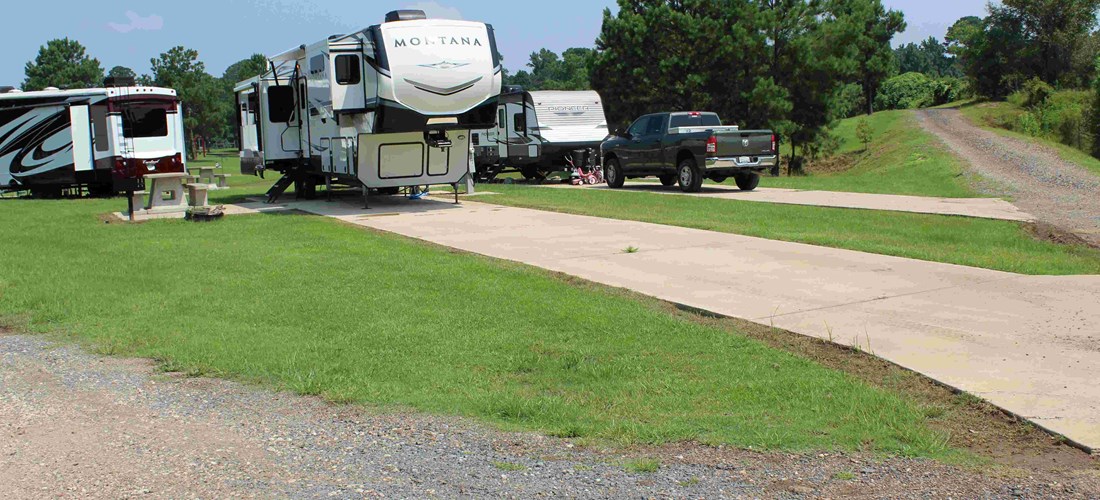 Our back-in sites in our West Campground offer everything you would expect from a campsite, including a long concrete pad, a picnic table, grill, and a fire pit.