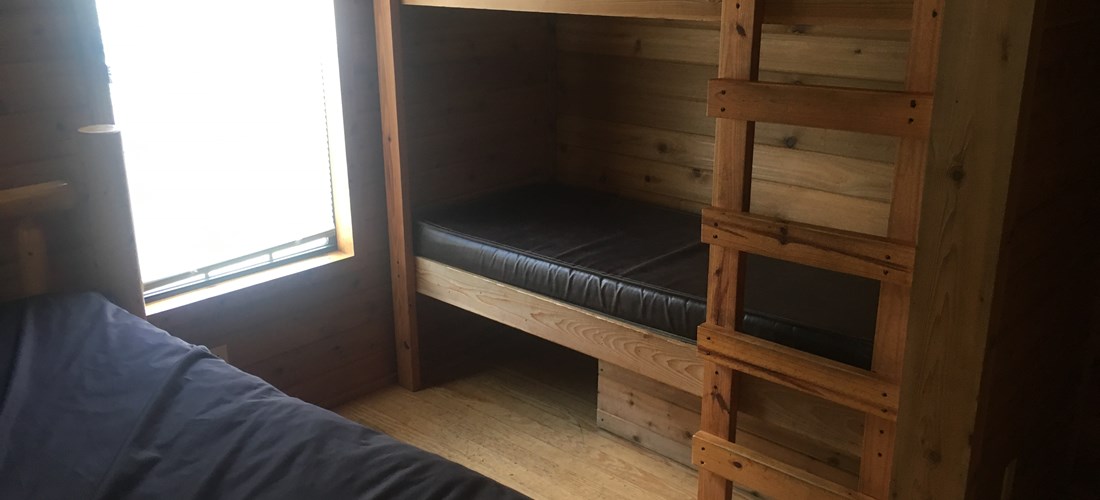 Bedroom area includes full bed and bunk beds