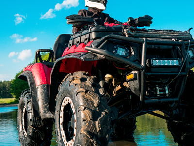 Rider on a red ATV on an off-road trail near Valdez KOA Journey.