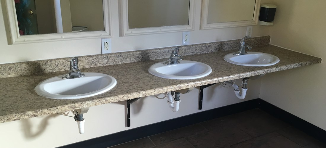Bathrooms with showers, toilets & sinks.