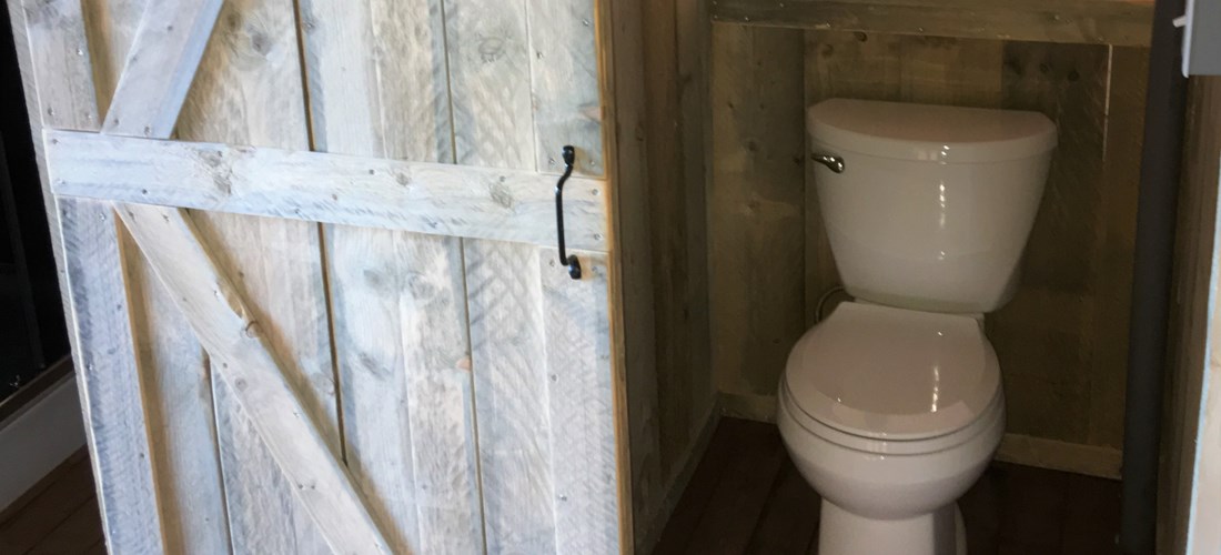 Toilet in separate room, next to shower/sink.