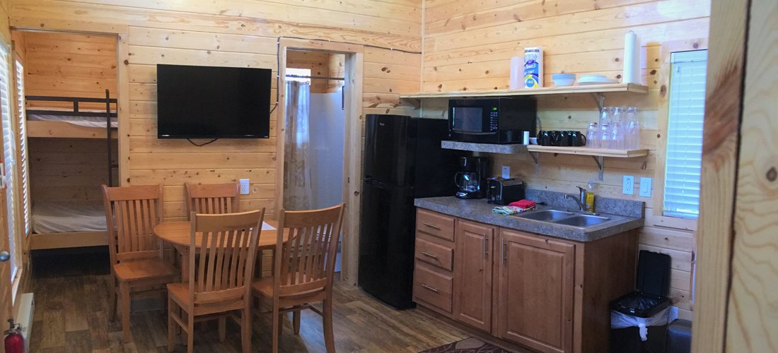 Partial kitchen inside with fridge/freezer; microwave; coffee maker; cooking utensils and dishes. Propane 2 burner cook-top on porch - just outside of the cabin.