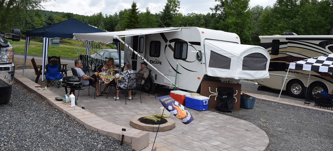 Deluxe Patio Pull Thru Site. Spacious site combined with a beautiful  patio, fire pit and outdoor furniture make for a great outdoor experience. 50/30amp elec. Non wooded.