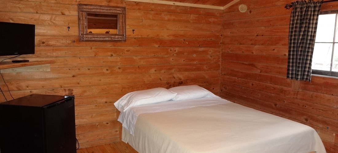 The interior of our Camping Cabin comes with a small TV and Mini Fridge.