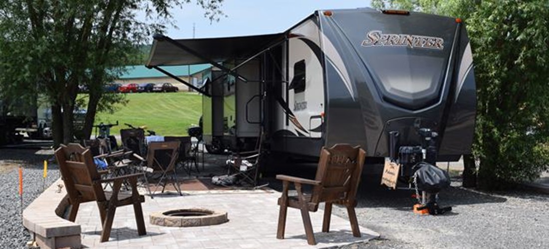 Deluxe Patio Pull Thru Site. Spacious site combined with a beautiful patio, fire pit and outdoor furniture make for a great outdoor experience. 50/30amp elec. Non wooded.