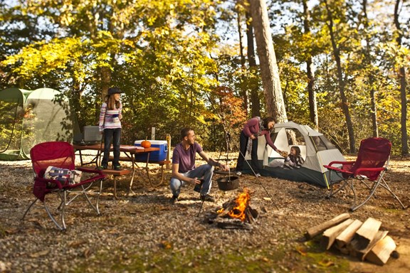 Smiling family experiencing the great outdoors while tent camping in the fall