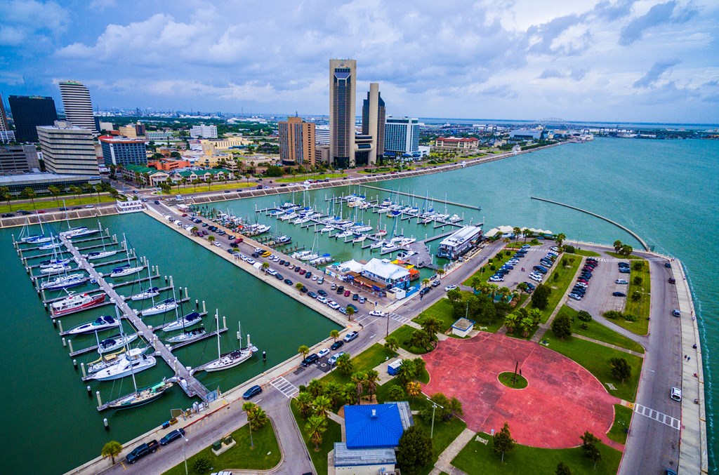 Aerial view of Corpus Christi, Texas with a marina full of boats in the foreground.